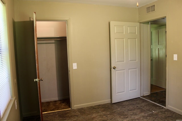 unfurnished bedroom featuring a closet, visible vents, and baseboards