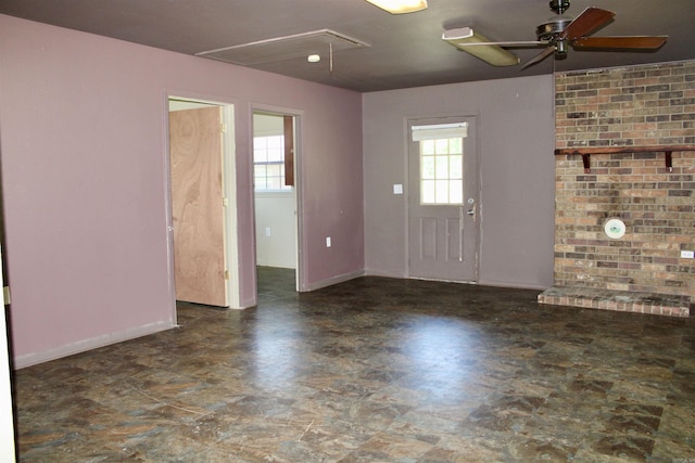 interior space featuring attic access, ceiling fan, and baseboards