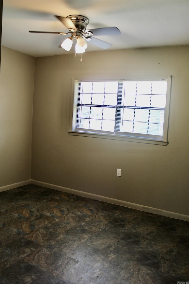 spare room featuring a wealth of natural light, ceiling fan, and baseboards