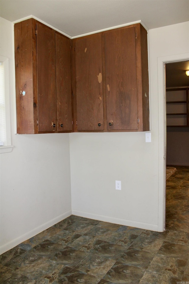 empty room featuring stone finish flooring and baseboards