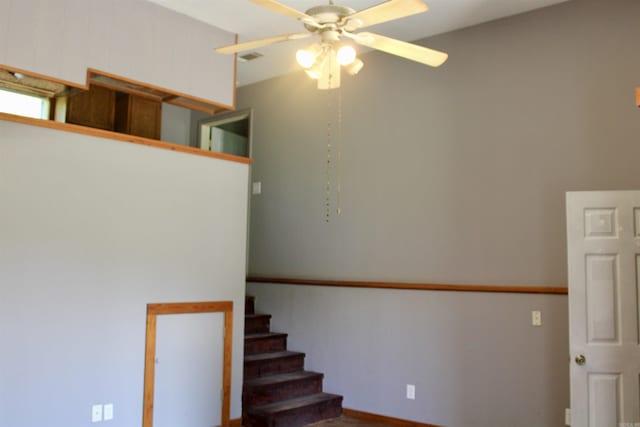 stairs featuring ceiling fan