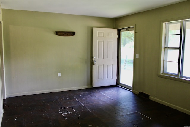 unfurnished room featuring baseboards and a wealth of natural light