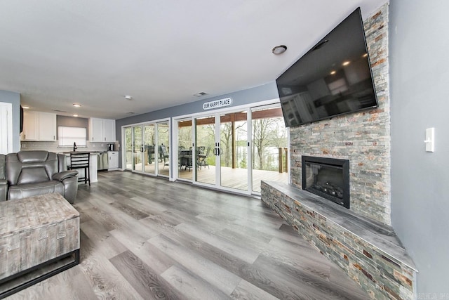 living room featuring sink, light hardwood / wood-style floors, and a fireplace