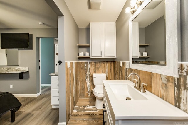 bathroom featuring wood-type flooring, toilet, and large vanity