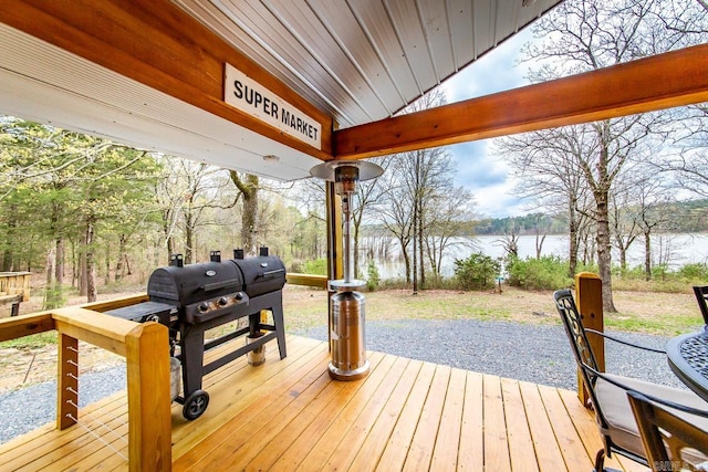 wooden terrace with a water view and a grill