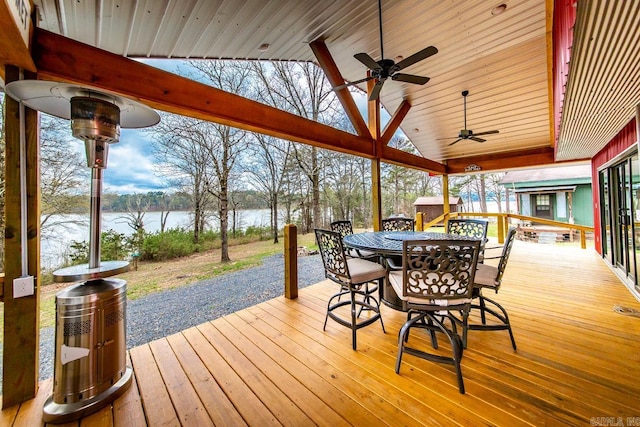 deck with ceiling fan and a water view