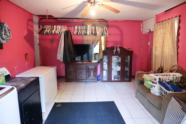 interior space with a textured ceiling, washing machine and dryer, light tile flooring, and ceiling fan