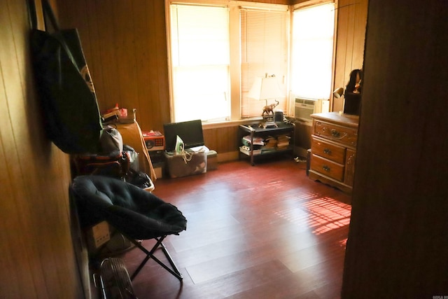 sitting room with wood walls and dark wood-type flooring