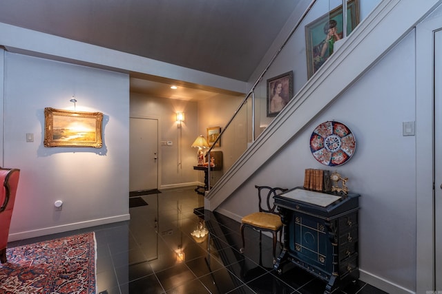 interior space with lofted ceiling, baseboards, and stairs