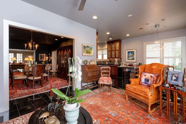 living area with a chandelier, dark tile patterned flooring, plenty of natural light, and recessed lighting