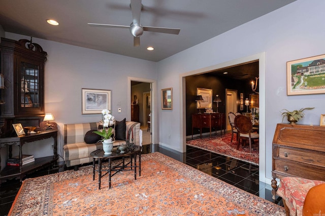 living area with a ceiling fan, recessed lighting, granite finish floor, and baseboards