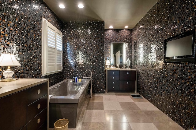 full bathroom featuring a garden tub, visible vents, two vanities, and recessed lighting