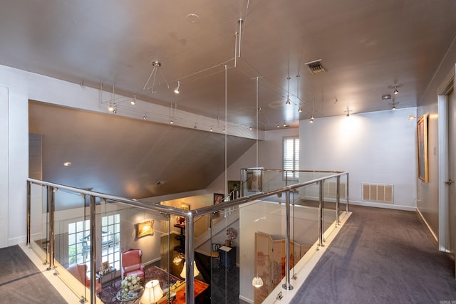 corridor with an upstairs landing, visible vents, and baseboards