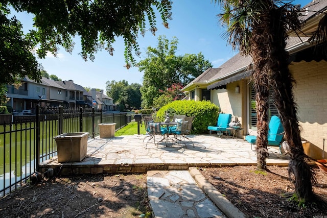 view of patio / terrace with outdoor dining area, fence private yard, and a residential view