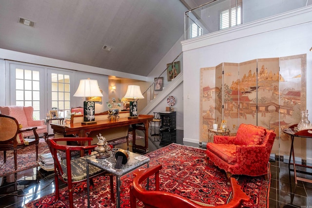 living room with a healthy amount of sunlight, granite finish floor, visible vents, and stairway