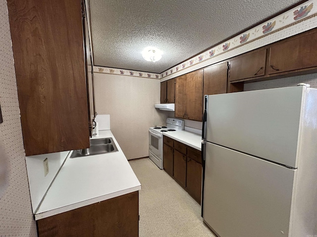 kitchen featuring a textured ceiling, dark brown cabinets, sink, and white appliances