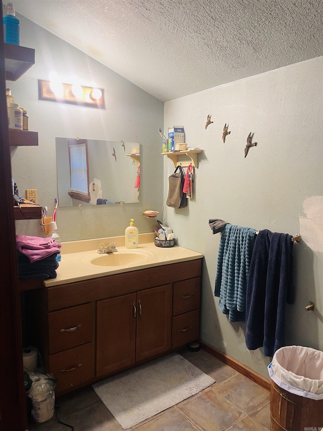 bathroom with tile patterned floors, vanity, and a textured ceiling