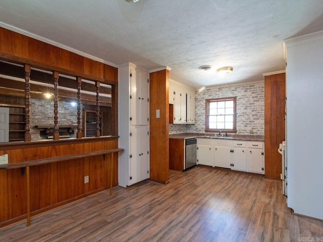 kitchen featuring dishwasher, backsplash, dark wood-type flooring, crown molding, and white cabinetry