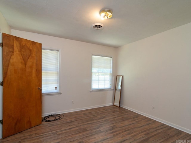 empty room with dark hardwood / wood-style flooring