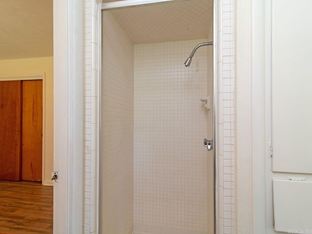 bathroom featuring hardwood / wood-style flooring and a shower with shower door