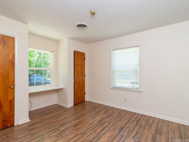 unfurnished bedroom with dark wood-type flooring