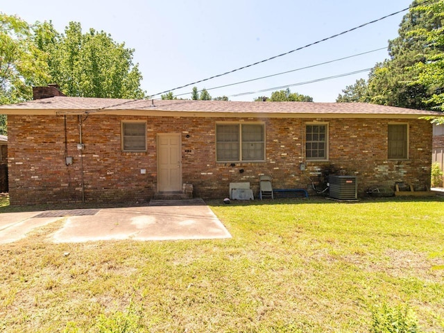 rear view of property featuring a lawn, central air condition unit, and a patio