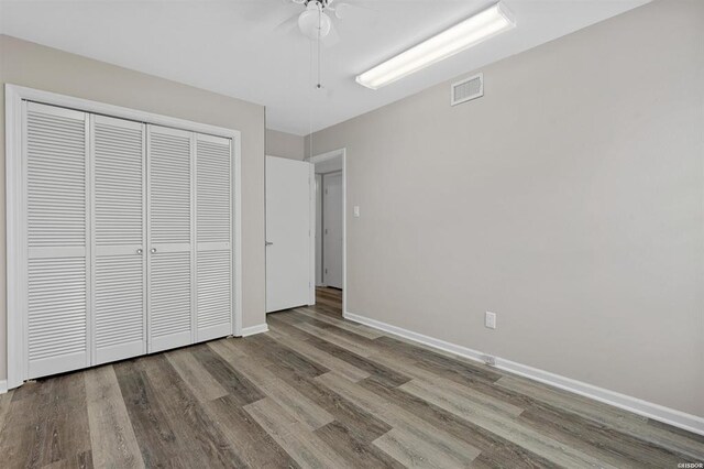 unfurnished bedroom with a closet, ceiling fan, and hardwood / wood-style floors