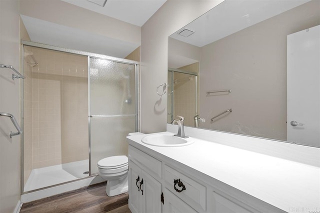 bathroom with hardwood / wood-style floors, oversized vanity, an enclosed shower, and toilet