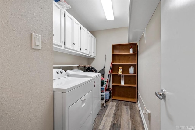 clothes washing area with washer and clothes dryer, cabinets, and light hardwood / wood-style flooring