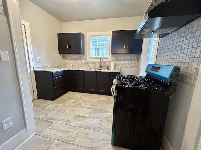 kitchen featuring sink, backsplash, range with gas cooktop, and light stone countertops