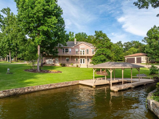 view of dock featuring a balcony, a lawn, and a water view