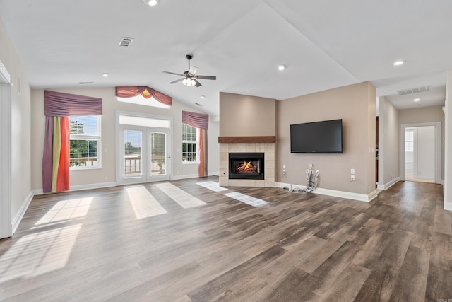 unfurnished living room with ceiling fan, vaulted ceiling, a fireplace, and wood-type flooring