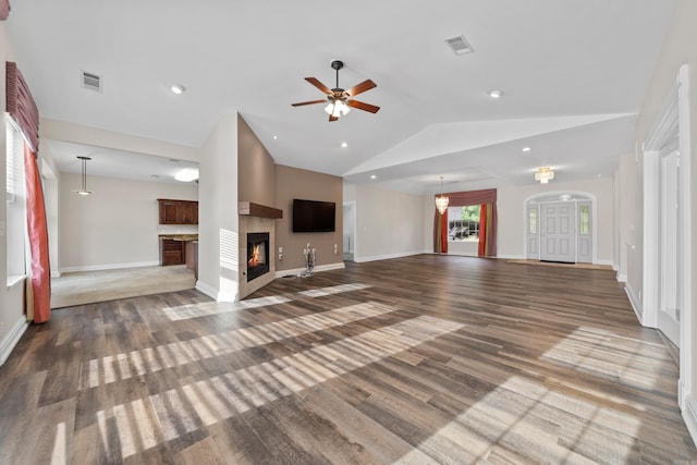 unfurnished living room with wood-type flooring, a multi sided fireplace, ceiling fan, and vaulted ceiling