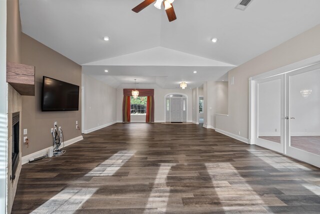 unfurnished living room featuring lofted ceiling, dark hardwood / wood-style floors, and ceiling fan with notable chandelier