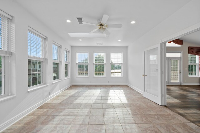 unfurnished sunroom featuring ceiling fan