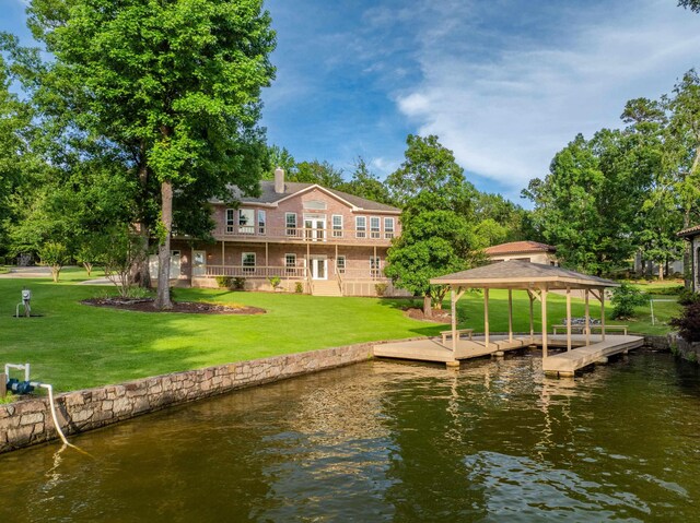 view of dock with a water view and a yard