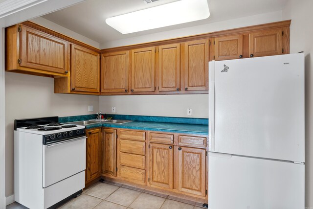 kitchen with sink, white appliances, and light tile floors