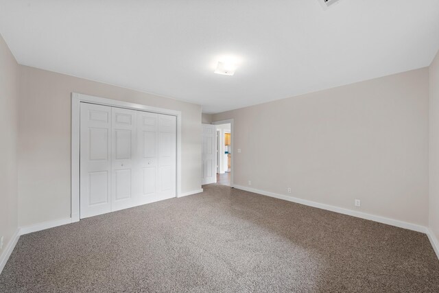 unfurnished bedroom with carpet and a closet