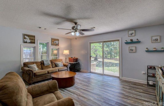 living room featuring ceiling fan, wood-type flooring, and a textured ceiling