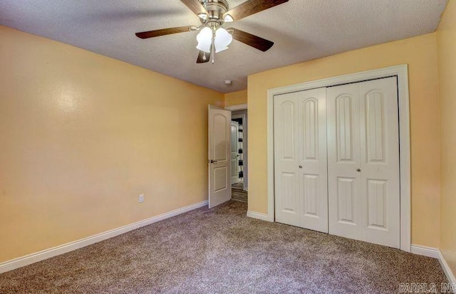 unfurnished bedroom with a textured ceiling, carpet floors, a closet, and ceiling fan