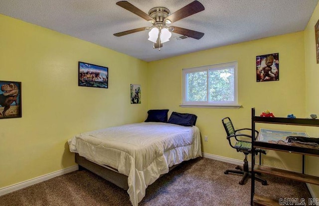 carpeted bedroom featuring ceiling fan and a textured ceiling