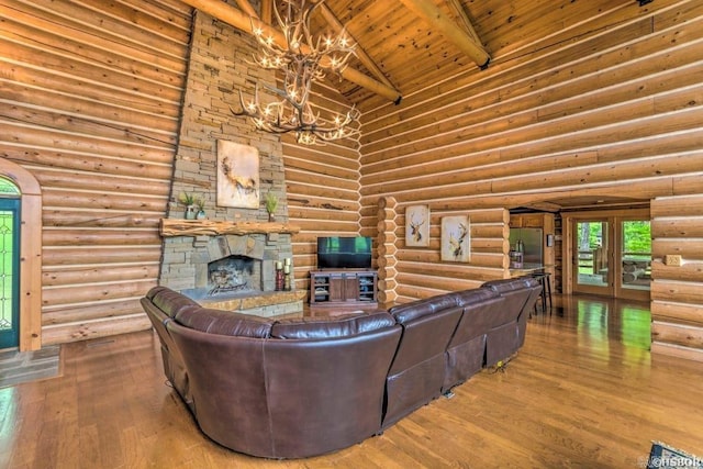 living room with rustic walls, wood ceiling, an inviting chandelier, high vaulted ceiling, and beamed ceiling