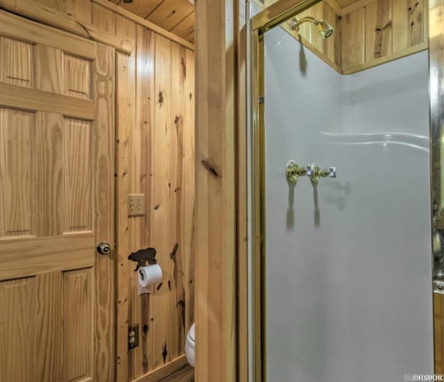 bathroom featuring wood walls and toilet