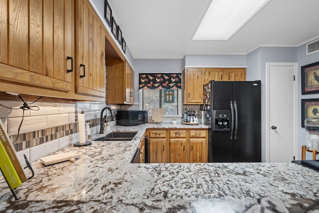 kitchen featuring kitchen peninsula, tasteful backsplash, ornamental molding, sink, and black appliances