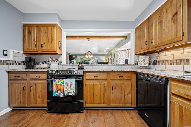 kitchen featuring pendant lighting, tasteful backsplash, hardwood / wood-style flooring, and black appliances