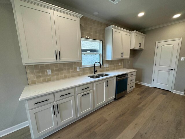 kitchen featuring crown molding, sink, hardwood / wood-style flooring, stainless steel dishwasher, and white cabinetry