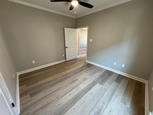 empty room with crown molding, ceiling fan, and hardwood / wood-style flooring