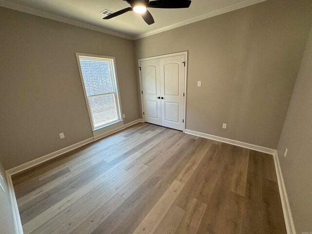 unfurnished bedroom featuring light wood-type flooring, ceiling fan, and crown molding