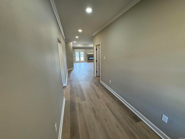 hall with crown molding and light hardwood / wood-style flooring