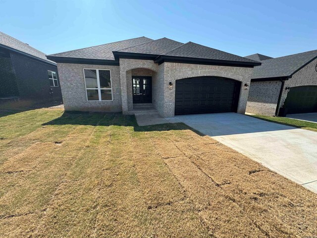 view of front facade with a garage and a front lawn